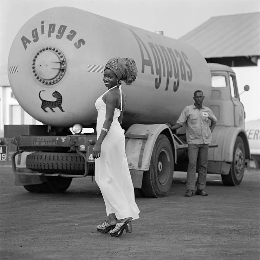 James Barnor, Model with Tank and Driver, 1974. Digital Fibre Print, 70 x 70 cm.Edition of 10 plus 1 artist’s proof. James Barnor, Model with Tank and Driver, 1974. Digital Fibre Print, 70 x 70 cm.Edition of 10 plus 1 artist’s proof.