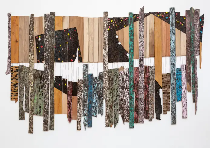 El Anatsui, Conjugation, 2024. Tropical hardwood, tempera, aluminium and copper wire. 124 x 370 cm (49 x 146 in). 